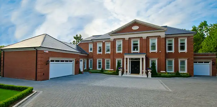 View from the driveway of a large brick home with an attached garage.