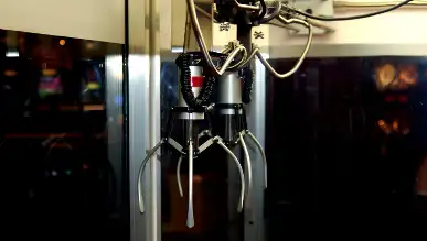 A mechanical claw pointing downward.