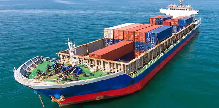 Aerial view of a shipping cargo ship in the middle of the ocean.